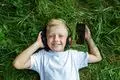 Kind; Musik; Kopfhörer; Kopfhoerer; hören; hoeren; Gras; Sommer; Freizeit; Hörbuch; Hoerbuch; entspannen; audio; Sommerferien; lachen; Spaß; Spass;
