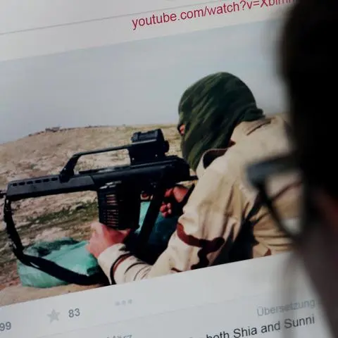 ILLUSTRATION - Eine junge Frau schaut am 12.03.2015 in Köln auf einen Computermonitor, auf dem einer Website mit Propaganda des IS zu sehen ist. Foto: Oliver Berg/dpa (zu dpa "Wie die Terrormiliz IS im Netz um Anhänger wirbt" vom 14.03.2015) ++ +++ dpa-Bildfunk +++