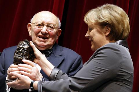 Marcel Reich-Ranicki hält mit Bundeskanzlerin Angela Merkel auf der Bühne im Hamburger Schauspielhaus nach der Verleihung des Henri-Nannen-Preises 2008 seine Bronzebüste hoch. Archivfoto: dpa