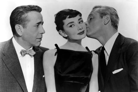 Audrey Hepburn mit Humphrey Bogart und William Holden in einem Bild aus Billy Wilders Filmkomödie „Sabrina” (1954).