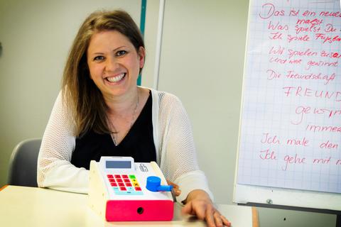 Anja Matthes aus Modautal unterrichtet ihre Deutschkurse für Flüchtlinge mit Herzblut – zum Beispiel auch mit einer Spielzeugkasse ihres Sohnes, mit der das Einkaufen geübt wird. Foto: May-Britt Winkler