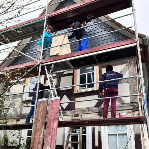 Zum Schluss gibt es noch einen Arbeitseinsatz: die ehrenamtlichen Helfer beim Streichen der Fassade.