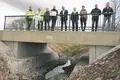 Florian Schmidt, Marco Römer, Niclas Heger, Julien Neubert (mit Förderbescheid), Stefan Jung-Diefenbach, Jennifer Herschbach, Leonie Roßberger, Ralf Ufer und Jens Janik (v.l.) bei der offiziellen Einweihung der neuen Brücke über den Weidgraben vor dem Rückhaltebecken in Lich.