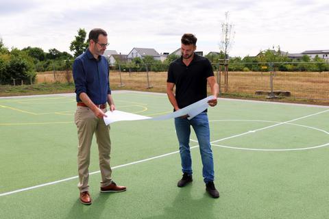 Im Plan: Stadrat Nils Kraft (links) und und Maximilian Henkelmann, Bereichsleiter Grünplanung, auf dem neuen Spielfeld am Blauen See. Foto: Stadt Rüsselsheim