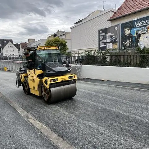 Bald wieder geöffnet: Eine Walze verdichtet den frischen Asphalt der Stadtunterführung Friedensstraße. 