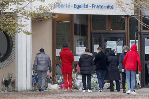 Schüler gedenken vor einer Schule in Conflans-Sainte-Honorine einem Lehrer, der bei einer mutmaßlich terroristisch motivierten Tat am Freitag ermordet wurde. Auch in Évreux, Rüsselsheims Partnerstadt, ist das Entsetzen groß. Foto: dpa