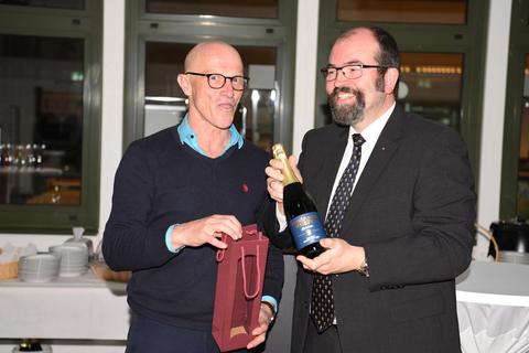 Georg Theisen (links), Bereichsleiter Internat der Beruflichen Schulen, überreicht Lions-Präsident Alexander von Renz (rechts) eine Flasche des bistumseigenen Sekts. 