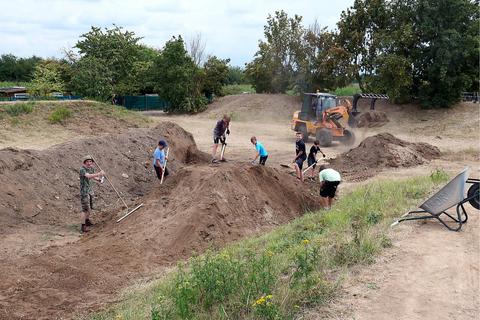 Baggerfahrer Shkelzen Maluko und die Jugendlichen sind beim Bau der neuen Hochheimer Mountainbike-Anlage ein unschlagbares Team. Foto: Ulrich von Mengden