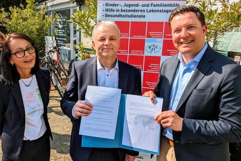 Caritas-Abteilungsleiterin Ute Schuler, Caritas-Vorstand Torsten Gunnemann und Bürgermeister Christian Vogt (von links) präsentieren den Vertrag. Foto: Stadt Hofheim 