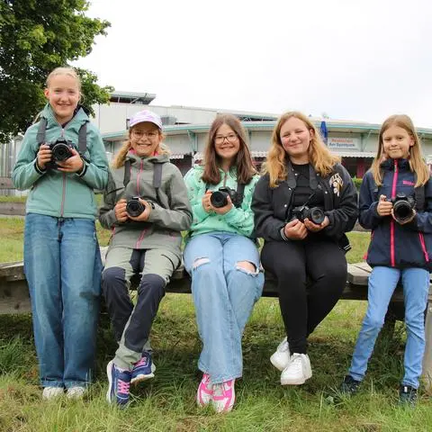 Mit Fotokamera und Notizblick auf der Suche nach einer spannenden Geschichte: Die fünf Ferienreporterinnen Clara Elisabeth Zimmermann (von links), Lynn Juna Glowe, Emely Stella Heck, Milena-Celine Müller und Lilly Schneider machen sich auf den Weg ins Mittelalter-Camp im Bad Endbacher Kurpark.