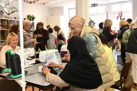 Bei der Eröffnung der neuen Nähwerkstatt der Philipp-Kraft-Stiftung war der Raum voll mit Besuchern. Statt zwei gibt es jetzt fünf Nähmaschinen. Foto: DigiAtel/Heibel