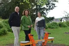 Marcus Hief, Leiter der EAM Netzregion Dillenburg/Biedenkopf, übergibt die neue Federwippe auf dem Spielplatz der Kita in Allendorf an Greifensteins Bürgermeisterin Marion Sander (Mitte) und die stellvertretende Leiterin der Kindertagesstätte "Kükennest", Lena Gütter. 