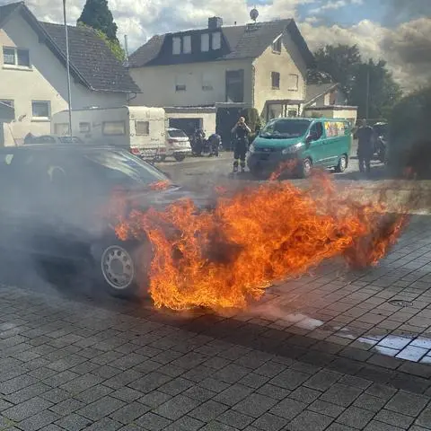 Flammen schlagen aus dem Motorraum eines Pkws in Hüttenberg. Die Ursache des Brandes ist bislang nicht bekannt. Die Hüttenberger Feuerwehr ist am Dienstagnachmittag mit vier Fahrzeugen und 25 Einsatzkräften vor Ort. 