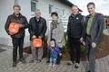 Roland Döpp (v. l.) und Wolfgang Schmitt zeigen die beiden neuen Defibrillatoren. Mit dabei sind Schmitts Ehefrau Beate mit Enkelin Marleen sowie Karsten Will und Bürgermeister Christian Walendsius.   