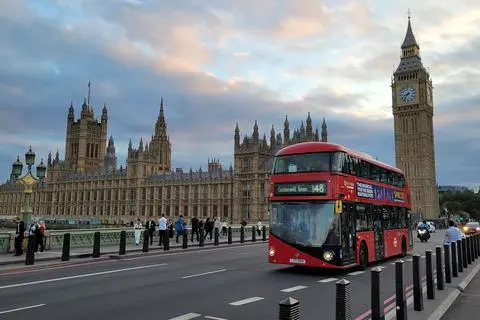 Roter Doppeldeckerbus vor „Big Ben“ in London: Weil dort Linksverkehr gilt, befindet sich bei den Bussen in Großbritannien der Aus- und Einstieg auf der linken Seite. In Wetzlar gibt es Hinweise darauf, dass auch dort bald auf der anderen Seite gefahren wird.