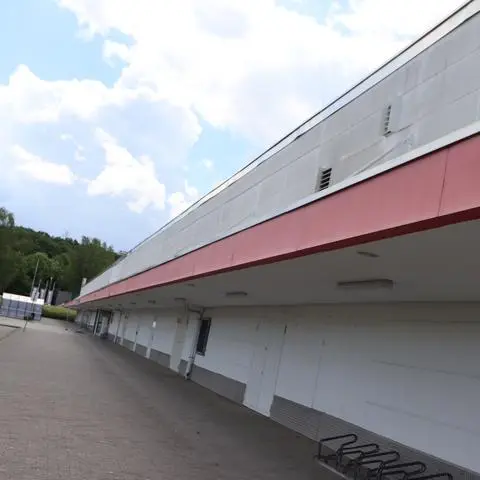 Die rote Kante des Vordaches zieht sich wie ein roter Faden durch die Architektur des ehemaligen Real-Marktes.