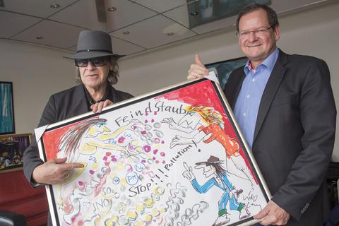 Die deutsche Rock-Legende Udo Lindenberg hat die Stiftung schon häufig mit selbstgemalten Bildern unterstützt, die dann versteigert wurden. Hier übergibt er 2018 das Bild "Fein(d)staub" an Professor Münzel. 