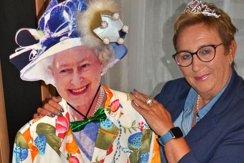Queen-Fan Birgit Maurer mit der Pappfigur von Elisabeth II., der sie den Lieblingsblazer ihrer verstorbenen Mutter angezogen hat.  Foto: Heidi Sturm