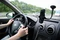 Eine Frau sitzt im Auto mit einem Smartphone in einer Halterung. (zu dpa: «Google Maps irritiert mit vermeintlichen Autobahnsperrungen»)