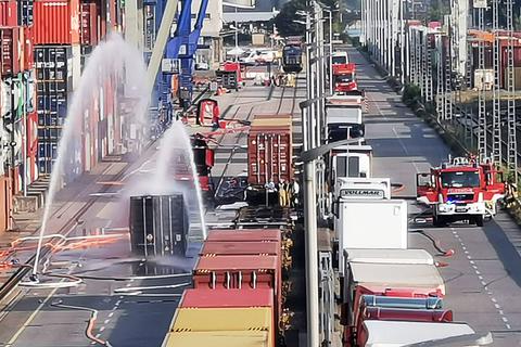 Die Feuerwehr kühlt einen Container, der mit 200 Fässern Hydrosulfit gefüllt ist.   Foto: dpa