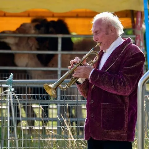Reportage Circus Hallygally: Senior Walter Frank spielt auch nach der Vorstellung weiter Trompete - selbst wenn ihm nur noch die Dromedare zuhören. 