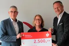 2500 Euro für eine Brandmeldeanlage in der Turnhalle Groß-Eichen: Oliver Senteck (r) und Manfred Görig überreichen an Jennifer Schomber den symbolischen Scheck.