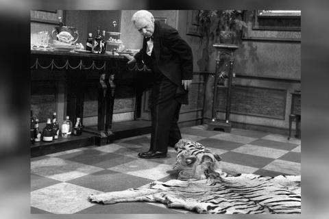 Freddie Frinton als Diener James betrachtet nach einem Stolpern das Tigerfell in einer Szene des Films "Dinner for One oder: der 90. Geburtstag".  Foto: dpa