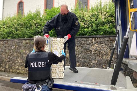 Polizeibeamte stellen eine Verteilersteckdose sicher. Foto: Jens Etzelsberger