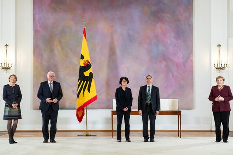 Ugur Sahin (2.v.r) und seine Frau Özlem Türeci (M), die Gründer des Mainzer Corona-Impfstoff-Entwicklers Biontech, stehen bei der Verleihung des Großen Verdienstkreuzes mit Stern des Verdienstordens der Bundesrepublik Deutschland im Schloss Bellevue mit Bundespräsident Frank-Walter Steinmeier und seiner Frau Elke Büdenbender (l) und Bundeskanzlerin Angela Merkel (CDU, r) zusammen. Foto: dpa