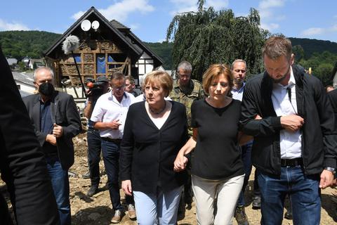 Kanzlerin Angela Merkel und Ministerpräsidentin Malu Dreyer gehen Hand in Hand durch das rheinland-pfälzische Schuld. Foto: dpa