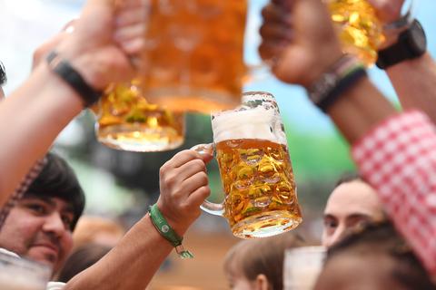 Bayern, München: Besucher prosten sich in einem Bierzelt mit Biergläsern zu.  Foto: picture alliance / Tobias Hase/dpa
