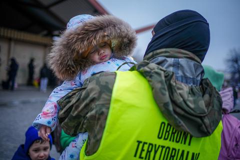 Ein polnischer Soldat trägt am frühen Morgen ein Kind am Bahnhof von Przemysl in der Nähe des ukrainisch-polnischen Grenzübergangs nach seiner Ankunft mit dem Zug aus Kiew. Hier kommen täglich Menschen an, die vor dem Krieg in der Ukraine fliehen. Foto: dpa