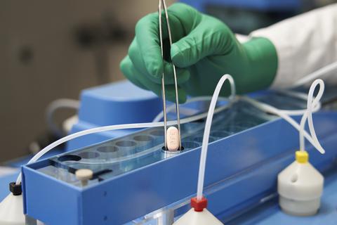 Ein Mitarbeiter von Pfizer hält eine Paxlovid-Tablette mit einer Zange. Die US-Arzneimittelbehörde FDA hat eine Notfallzulassung für ein Corona-Medikament des US-Herstellers Pfizer ausgesprochen.  Foto: -/Pfizer/AP/dp