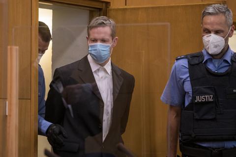 Stephan E. (M), der des Mordes an dem Politiker Lübcke angeklagt ist, wird am ersten Tag des Prozesses mit Mundschutz von Polizisten in einen Gerichtssaal des Oberlandesgerichts gebracht.  Foto: dpa