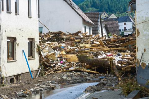 Schutt liegt aufgetürmt auf einer Straße in dem Ort Schuld im Kreis Ahrweiler nach dem Unwetter mit Hochwasser.  Foto: dpa