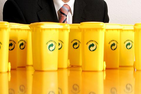 Kleine gelbe Tonnen mit dem "Grüner Punkt"-Logo stehen auf einem Tisch. Doch wie viele recycelbaren Materialien werden wirklich wiederverwertet? Symbolfoto: dpa