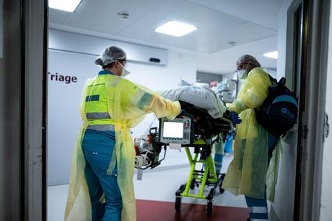 Die Besatzung eines niederländischen Krankenwagens schiebt einen Covid-19-Patienten aus den Niederlanden im St. Elisabeth Hospital an einem Raum mit der Aufschrift "Triage" vorbei.