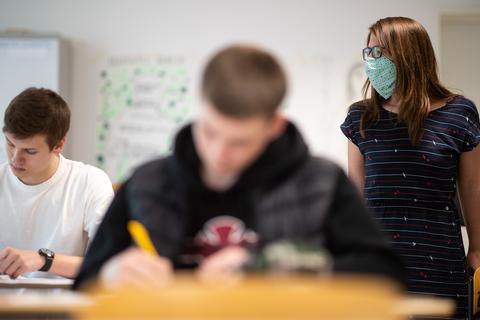 So könnte der Unterricht in der Oberstufe am Montag aussehen: Lehrerin mit Schutzmaske, Schüler ohne. Foto: dpa