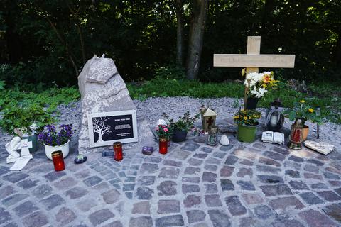 Ein Holzkreuz und Kerzen steht an einer Landstraße zwischen Kusel und Ulmet an der Gedenkstätte für zwei getötete Polizisten.