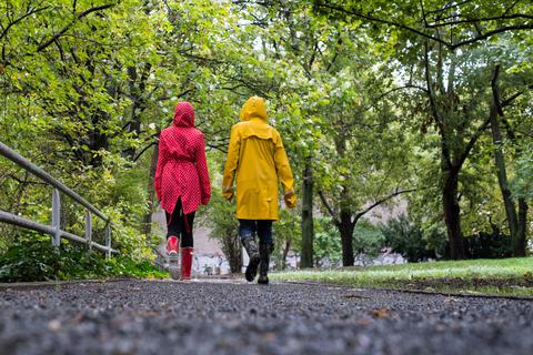 Spaziergänger schützen sich mit Regenjacken vor schlechtem Wetter. Outdoor-Kleidung sollte gut gepflegt werden.  Foto: Franziska Gabbert/dpa