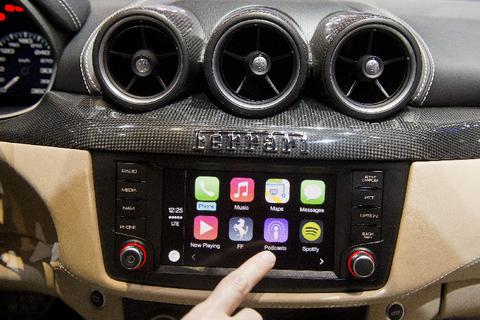 Mit CarPlay - hier demonstriert auf dem Genfer Autosalon in einem Ferrari FF - will Apple bei der Autoelektronik mindestens Fuß in die Tür bekommen - und wie man den Konzern kennt, weiß man, dass es dabei nicht bleiben wird. Foto: dpa