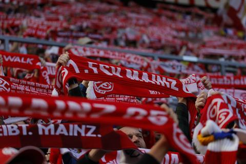 Fans des 1. FSV Mainz 05 halten ihre Schals nach oben. Foto: Tim Würz