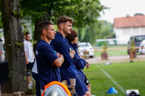 Matej Maglica schaut sich mit Kollege Fabian Schnellhardt (links) das Geschehen auf dem Sportplatz in Hayna an.