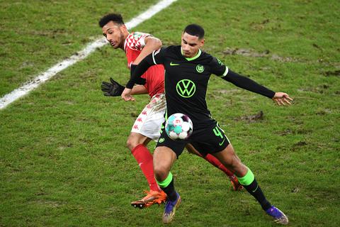 Der Mainzer Karim Onisiwo spielt gegen Wolfsburgs Maxence Lacroix (r.). Foto: Torsten Silz/dpa