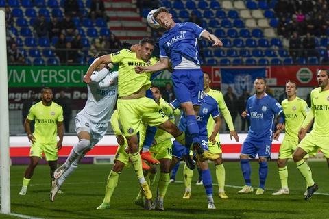 Vorne geht SVWW-Spieler John Iredale (gelbes Trikot) gerade in ein Kopfballduell.