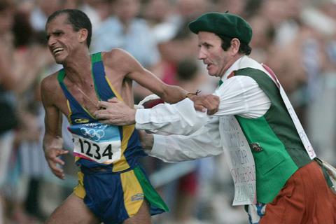 Vanderlei Lima (links) wird von Cornelius Horan festgehalten und um sein olympisches Marathongold gebracht. Archivfoto: dpa