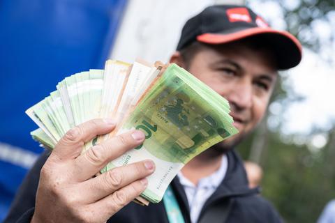 Einer der streikenden Lkw-Fahrer mit einem Bündel Geldscheinen in der Hand.